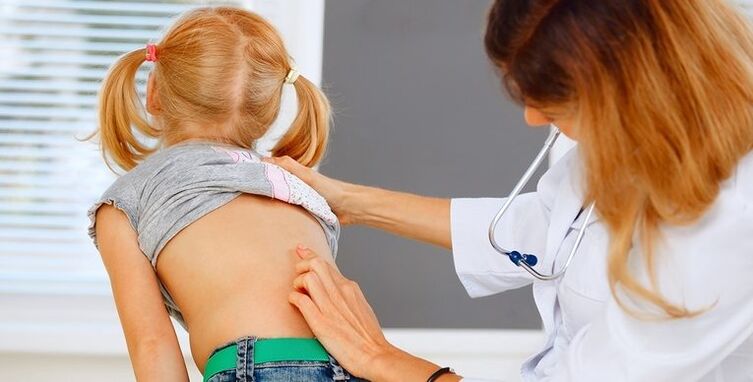 doctor examines child's back for lower back pain